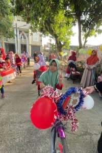 Salah satu peserta karnaval berpose di depan sepeda hiasnya
